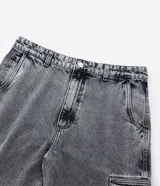 Pantalón de jean gris con efecto acid wash, modelo baggy de corte ancho, cintura con trabillas y bolsillos cargo en los laterales.