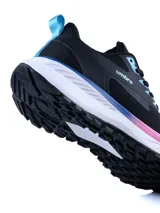 Championes deportivos Umbro modelo Tread, color negro con detalles en celeste y rosado en la suela y ojales. Presentan un diseño de malla transpirable con refuerzos laterales y suela blanca con amortiguación.