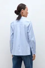 Camisa de manga larga color celeste, con cuello clásico y botones frontales.