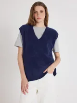 Chaleco de punto sin mangas color azul marino, con escote en V, hombros extendidos y aberturas laterales, confeccionado en suave cachemira con textura afelpada.
