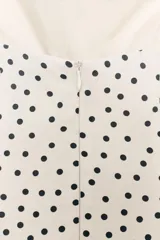 Vestido midi de corte fluido con escote halter y lazada ajustable al cuello. Presenta un diseño con estampado de lunares y falda con volumen.