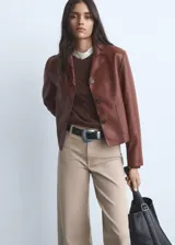 Jeans tiro alto estilo culotte de color beige claro, con diseño de pernera ancha, bajo deshilachado y cierre de cremallera y botón.