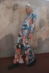 Pantalón palazzo de crepe de seda estampado con motivos florales en tonos fucsia, rojo y blanco. Tiene cierre invisible lateral y costura francesa.