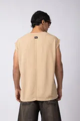 Musculosa oversize de tejido texturado color crema, con cuello redondo y terminaciones deshilachadas en las sisas. Presenta una costura central vertical en la espalda.