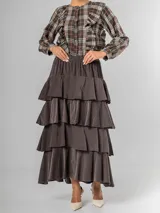 Falda larga de micro corderoy color marrón oscuro, con diseño de volados en capas y elástico en toda la cintura.