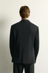 Blazer slim fit de Zara en color negro, confeccionado con mezcla de viscosa. Cuenta con cuello de solapas de muesca, cierre frontal de un botón, bolsillos con solapa en la cadera y un bolsillo de vivo en el pecho.