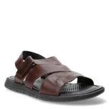 Sandalias de cuero marrón con tiras cruzadas y cierre de velcro en el talón, montadas sobre una suela ergonómica negra.