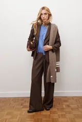 Pantalon de corte recto y pierna ancha, confeccionado en tejido tipo denim oscuro. Presenta tiro alto, cintura con cierre frontal y bolsillos laterales funcionales.