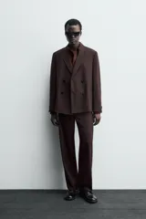 Blazer de traje cruzada de corte regular fit, color marrón oscuro, con solapas de muesca, bolsillos de doble vivo en la cadera y cierre frontal de botonadura doble.