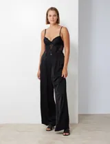 Pantalón palazzo de satén con tiro alto, pretina con pasadores, cierre y botón frontal, y elástico en la parte trasera. Cuenta con bolsillos laterales verticales.