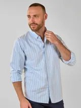 Camisa celeste a rayas verticales blancas, de manga larga y corte clásico.