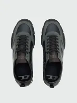 Zapatillas deportivas Diesel modelo S-Pagodha, con diseño de paneles en cuero y gamuza en tonos verde oscuro y negro. Presentan suela de goma robusta con relieve geométrico que se extiende hacia la puntera, cordones negros y detalle de logo en la lengüeta.