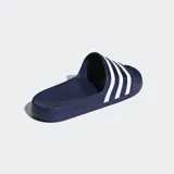 Sandalias tipo chinela Adidas Adilette, color azul marino con tres franjas blancas en la tira superior. Poseen plantilla contorneada y suela de poliuretano.