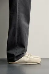 Zapatilla deportiva barefoot de hombre, confeccionada en combinación de piezas de piel con acabado serraje en color marrón, con cordones y suela fina de goma en contraste.