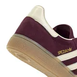 Zapatillas Adidas Handball Spezial color borgoña con las tres rayas laterales en blanco y suela de goma color caramelo.