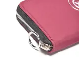 Billetera tipo fichero de color bordó, con cierre perimetral y logo metálico circular de la marca XL Extra Large en el centro.
