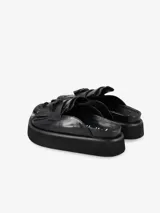 Zueco negro de cuero con plataforma y flecos.