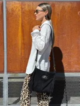 Bandolera negra de cuero con forro interno de tela.