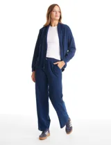 Pantalón tipo jogger de algodón con elastano, de corte recto y pierna ancha. Presenta cintura elastizada con cordón de ajuste y bolsillos laterales insertados en la costura.
