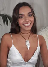 Collar con dije irregular de nácar engarzado en un capuchón plateado y tiento de cuero marrón.