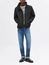 Campera negra de Tommy Hilfiger, modelo Regatta, con cuello alto, cierre de cremallera, dos bolsillos laterales y logo engomado bordado en la manga.