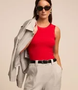 Top sin mangas color rosa claro, de corte ajustado, con cuello redondo y ribete de satén en el cuello y las sisas.