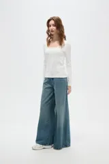 Top de manga larga color blanco, con cuello redondo amplio y ajuste al cuerpo.