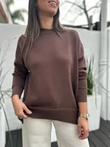 Sweater de punto color marrón chocolate, con cuello redondo, mangas largas y puños y ruedo acanalados. Presenta un diseño holgado y cómodo.