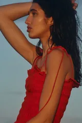Vestido midi rojo en mezcla de viscosa, con cuerpo fruncido tipo nido de abeja, escote recto, tirantes finos ajustables con moñas y falda amplia con vuelo.