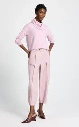 Polera de punto fino color rosa, con cuello holgado tipo cowl y mangas largas con puños ajustados.
