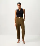 Pantalón carrot de tiro alto color verde militar, confeccionado en crepé, con elástico en la cintura posterior, cierre delantero con cremallera y botón, y bolsillos laterales.
