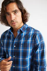 Camisa de manga larga con cuello clásico y cierre frontal abotonado. Presenta un estampado de cuadros en tonos azul marino y rojo. Confeccionada en algodón, cuenta con un corte slim fit y logo bordado en el pecho.
