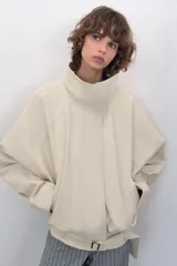 Chaqueta bomber oversize de efecto piel en color crema, con cuello subido, manga larga con hombro caído y cintura con frunces y cinturón ajustable con hebilla metálica. Cuenta con cierre frontal oculto y bolsillos laterales de vivo.