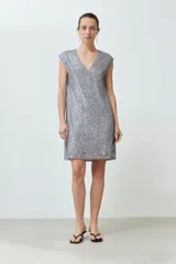 Vestido corto plateado con lentejuelas, escote en V y mangas cortas.
