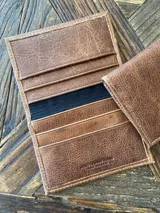 Tarjetero de cuero vacuno color marrón con seis ranuras para tarjetas y costuras reforzadas.