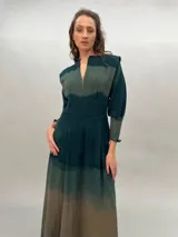 Vestido largo verde con efecto degradado, mangas largas abullonadas y falda con tajos laterales.