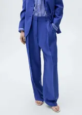 Pantalon de vestir color azul, de corte wide leg y tiro alto. Presenta pinzas delanteras, bolsillos laterales y cierre frontal con botón y cremallera oculta.