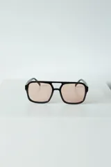Lentes de sol con armazón de policarbonato negro y cristales tintados en tono ámbar, con diseño de estilo retro y protección UV400.