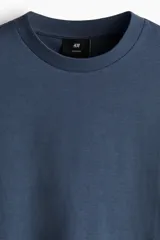Remera de punto de algodón con corte oversized, cuello redondo acanalado y diseño de hombros caídos.