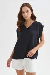 Blusa azul marino de viscosa, con cuello en V, sin mangas y diseño holgado.