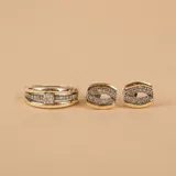 Anillo de diseño ancho compuesto por una banda central de oro pulido flanqueada por dos bandas laterales de plata con textura arenada. El segundo anillo es una alianza de plata y oro con una hilera central de circonias engastadas.
