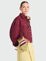 Mini bolso cruzado de Longchamp, diseñado con la estética de un par de manoplas de lana verde con franjas blancas y bordó, y solapa de cuero marrón con cierre de broche a presión.