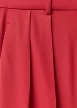 Pantalón de vestir rojo de corte wide leg, tiro alto y detalle de pliegues.