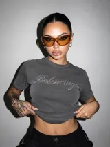 Remera gris oscuro de manga corta y cuello redondo, con efecto lavado y estampado brilhante con la inscripción "Balenciage" en el frente.