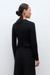 Cardigan negro de manga larga con cuello redondo y cierre frontal de botones. Presenta un tejido con patrones estructurados y un borde festoneado en el dobladillo.