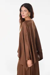 Blusa de algodón azul marino con escote en V, mangas murciélago amplias y diseño corto de corte asimétrico.