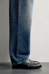 Zapato de vestir tipo monk de color negro, con detalle de doble hebilla metálica plateada en el empeine, puntera redondeada y suela con ligero tacón.