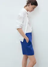 Short azul de lino con tiro medio, bolsillos laterales y diseño recto con cierre oculto.