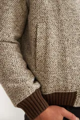 Campera estilo bomber color beige con textura, cierre delantero, cuello, puños y ruedo tejidos. Forrada, confeccionada en lana fina sin teñir.