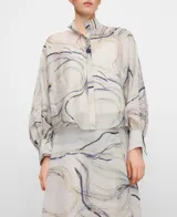 Top estampado semitransparente de línea amplia, cuello tirilla, manga murciélago y botonadura frontal oculta. Incluye top interior de tirantes.